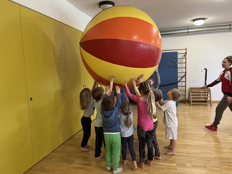 Kinder halten einen Riesenball in die Höhe
