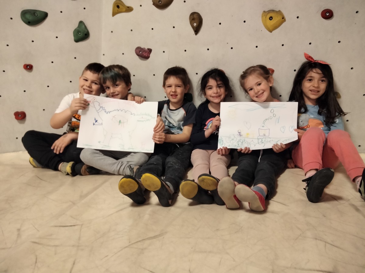 Kinder halten Bilder, welche sie an der Kletterwand gemalt haben